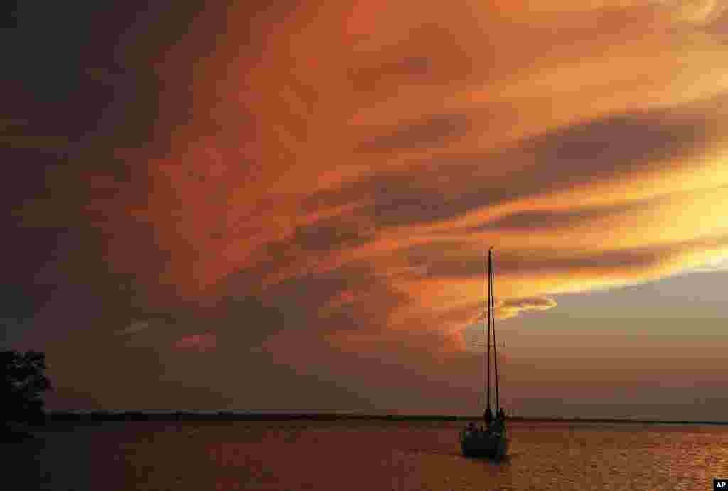 A boat returns to the harbor as the sun sets at Lake Hefner in Oklahoma City, Oklahoma, USA.