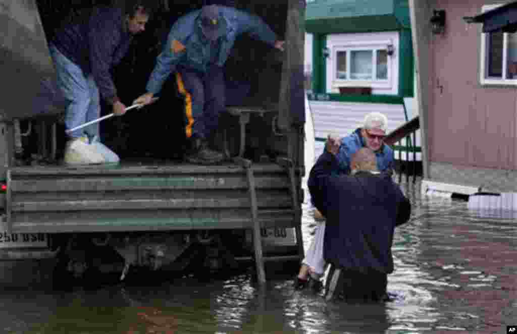 A woman is lifted into a National Guard vehicle after leaving her flooded home at the Metropolitan Trailer Park in Moonachie, N.J. Tuesday, Oct. 30, 2012, after supsterstorm Sandy.