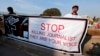 FILE - Pakistani journalists hold a banner while taking part in a demonstration in front of the Parliament building in Islamabad, January 2013. 