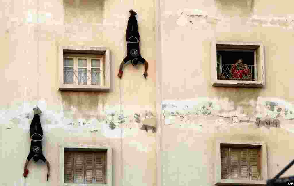 Palestinian militants of the Ezzedine al-Qassam Brigades, Hamas&#39;s armed wing, display their skills during an anti-Israel parade in the Gaza Strip as part of the celebrations marking the first anniversary of an Israeli army operation.