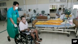 Một tình nguyện viên chăm sóc một bệnh nhân tại một bệnh viện ở Lopburi, Thái Lan.