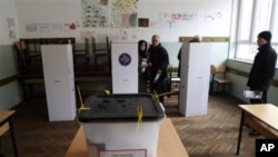 A Kosovo couple prepare to vote at a polling station in general elections in Kosovo's capital Pristina, 12 Dec 2010