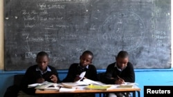 Children work on their teacher's table inside a classroom as a nationwide strike, by Kenyan teachers demanding a salary increase, left most of the country's learning institutions paralyzed in Nairobi, June 25, 2013. 