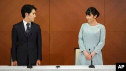 Japan's former Princess Mako, right, the elder daughter of Crown Prince Akishino and Crown Princess Kiko, and her husband Kei Komuro, look at each other during a press conference to announce their marriage at a hotel in Tokyo, Japan Tuesday, Oct. 26, 2021. (Nicolas Datiche/Pool P