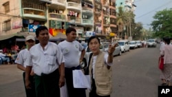 A Burma census enumerator and volunteers walk in a Muslim neighborhood collecting information in Rangoon, March 30, 2014. 