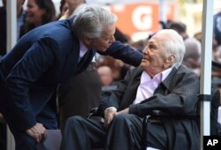 Honoree Michael Douglas, left, speaks with his father Kirk Douglas before a Hollywood Walk of Fame star ceremony, Nov. 6, 2018, in Los Angeles.