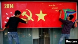 Công nhân đánh bóng poster mừng Tết Nguyên đán trên đường phố ở Hà Nội, ngày 23/1/2014.