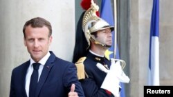 French President Emmanuel Macron welcomes a guest before a meeting at the Elysee Palace in Paris, France, May 23, 2018. 