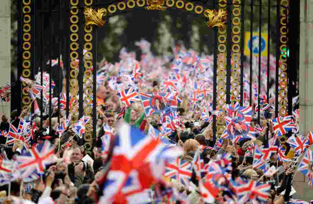 People wave British flags outside Buckingham Palace during the wedding. (Reuters/Dylan Martinez)