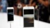 مشتریان آیفون شش در شعبه اپل در نیویورک ویژگی های گوشی جدید را بررسی می کنند.