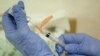 FILE - A nurse practitioner prepares a flu vaccination in Rockville, Maryland, Aug. 27, 2010. 