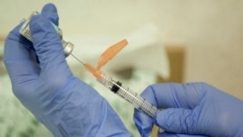 FILE - A nurse practitioner prepares a flu vaccination in Rockville, Maryland, Aug. 27, 2010.
