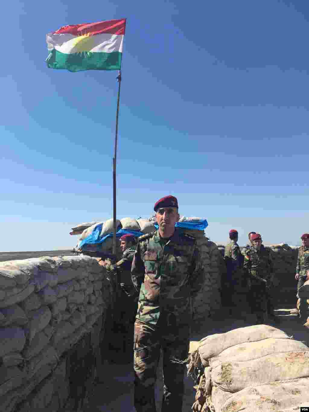 A Peshmerga commander walks along a wall of sandbags protecting the Iraqi Kurdish forces' last military base on the frontline with Islamic State in the Makhmour area of Iraq, March 8, 2016. (S. Behn/VOA)