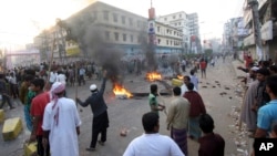 Jamaat-e-Islami activists, protesting sentences handed down by a war crimes tribunal, block traffic by them in Bogra, Bangladesh, March 3, 2013.