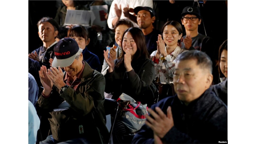 Fans of the Japanese writer Haruki Murakami celebrate after they heard that Japanese-born Kazuo Ishiguro won the Nobel Prize for Literature while they gather in a shrine with the hope of celebrating Murakami's winning in the prize in Tokyo, Japan, Oct. 5,