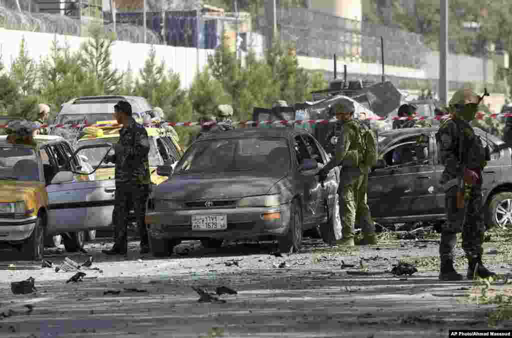 NATO and Afghan security forces inspect the site of a suicide attack in Kabul, Sept. 16, 2014.