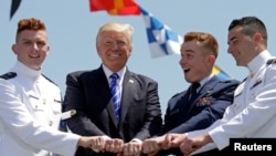 El presidente Donald Trump posa con algunos de los recién graduados.