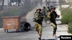 Tentara Israel lari saat bentrok dengan demonstran Palestina di Jalur Gaza, Jumat (25/7).