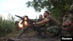 FILE - Members of the Ukrainian armed forces fire a grenade launcher, in response to what servicemen said were shots fired from the positions of fighters of the separatist self-proclaimed Donetsk People's Republic, in the town of Avdiivka, Donetsk region,