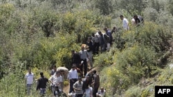 Syrians cross the border into Lebanon as they flee the violence in the Syrian village of Talkalakh, in the Wadi Khaled area, about one kilometer (0.6 miles) from the Lebanon-Syria border, north of Lebanon, May 16, 2011