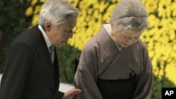 Japan's Emperor Akihito, left, escorts Empress Michiko after offering prayers for the war dead during a memorial service at Budokan Martial Arts Hall in Tokyo, Aug. 15, 2012.