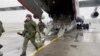 A still image from video released by Russia's Defence Ministry shows Russian service members disembarking from a military aircraft, at an airfield in Kazakhstan, Jan. 7, 2022. 