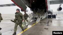 A still image from video released by Russia's Defence Ministry shows Russian service members disembarking from a military aircraft, at an airfield in Kazakhstan, Jan. 7, 2022. 