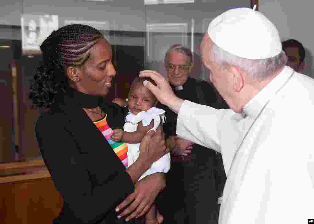 Trong bức ảnh do báo L&#39;Osservatore Romano của Vatican cung cấp, Đức Giáo hoàng gặp gỡ cô Meriam Ibrahim, người Sudan, cùng với cô con gái Maya, tại tư thất Santa Marta của Ngài ở Vatican. Người phụ nữ Sudan này bị kết án tử hình ở Sudan vì không chịu từ bỏ đức tin Kitô giáo của mình. Cô đến Italia cùng với gia đình mình, bao gồm đứa con mới sinh trong tù