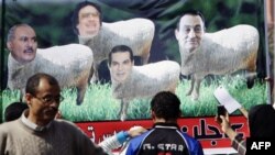 Egipćani posmatraju transparent sa likovima libijskog predsednika Gadafija, egipatskog bivšeg predsednika Hosnija Mubaraka, jemenskog predsednika Alija Abdulaha Saleha i bivšeg tuniskog predsednika Ben Alija