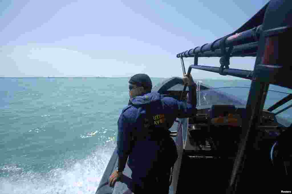 A Malaysia Maritime officer looks out into the sea during a search and rescue in Kuala Langat outside Kuala Lumpur, off Malaysia's western coast, June 18, 2014.