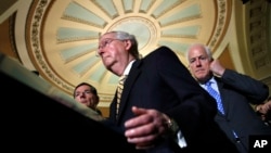 Senate Majority Leader Mitch McConnell of Kentucky, center, with Senate Majority Whip John Cornyn of Texas, right, and Sen. John Barrasso of Wyoming, talks to reporters on Capitol Hill in Washington, July 25, 2017.