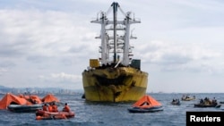 Rescuers search for survivors and bodies near a cargo vessel, which collided with a ferry on Friday, in Talisay, Cebu, August 17, 2013. 