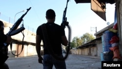 Two Lebanese Sunni gunmen hold weapons in Bab Al Tabbaneh, a Sunni district, in the northern Lebanese town of Tripoli May 26, 2013. 