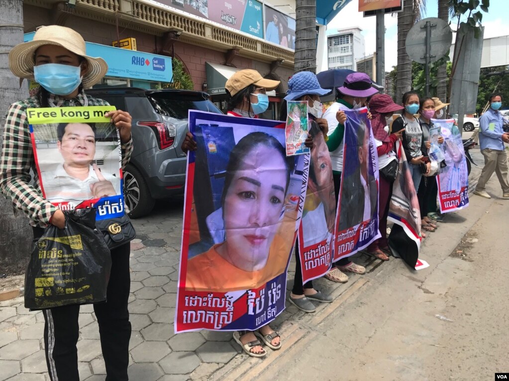 អ្នកតវ៉ានៅសាលាដំបូងរាជធានីភ្នំពេញ កាលពីថ្ងៃទី១ ខែកក្កដា ឆ្នាំ២០២១ កាន់រូបថតជនជាប់ចោទដែលបានតវ៉ាមួយចំថ្ងៃ២៣តុលា ឆ្នាំ២០២០ នៅមុខស្ថានទូតចិន។ (ហ៊ុល រស្មី/វីអូអេ)