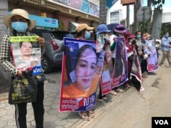 Protesters in front of Phnom Penh Municipal Court on July 1, 2021 hold photos and call for the release of accused persons who protested on October 23, 2020 - an anniversary of Cambodia’s Paris Peace Agreements - in front of the Chinese Embassy in Phnom Penh. (Hul Reaksmey/VOA Khmer)