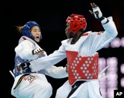 FILE - South Korea's Hwang Kyung-seon fights Ivory Coast's Ruth Gbagbi, in red, during their match in the women's taekwondo competition at the 2012 Summer Olympics in London, Aug. 10, 2012.