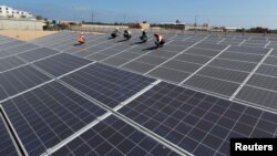 Palestinian workers install solar panels at Khan Younis Waste Water Treatment Plant, in the southern Gaza Strip July 31, 2018. Picture taken July 31, 2018.