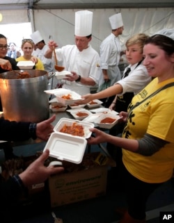 FILE - Volunteers hand out free meals made from rescued ingredients organized by the charity organization Oz Harvest in Sydney's central business district, July 29, 2013. The organizers goal is to feed 5,000 people over a lunch period in a bid to raise awareness to the amount of food wasted each day.