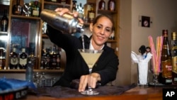 Cuban bartender Barbara Betancourt Bernal pours a daiquiri at a bar in Havana, Aug. 27, 2018.
