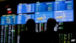 Suasana di depan papan elektronik di Tokyo Stock Exchange, Jepang, 21 Juni 2013 (Foto: dok). Bursa saham Asia kembali jatuh, menyusul melambannya laju pertumbuhan China yang lebih lambat dan pengurangan stimulus moneter oleh Bank Sentral Amerika, Selasa (25/6).