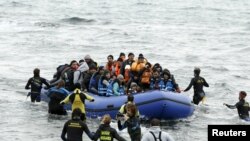 refugees and migrants as they arrive on a beach on the Greek island of Lesbos, January 29, 2016.