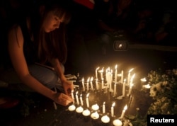 A woman lights candles at the Erawan shrine, the site of Monday's deadly blast, in central Bangkok, Thailand, August 18, 2015.