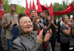 FILE - People applaud a speaker during a protest against raising the retirement age and reforming the pension system, at Sokolniki Park, in Moscow, Russia, July 18, 2018.