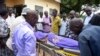 FILE - Relatives and other mourners watch as the body of South Sudanese journalist Peter Julius Moi is taken into the mortuary in Juba, South Sudan, Aug. 20, 2015. 