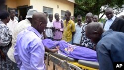 FILE - Relatives and other mourners watch as the body of South Sudanese journalist Peter Julius Moi is taken into the mortuary in Juba, South Sudan, Aug. 20, 2015. 