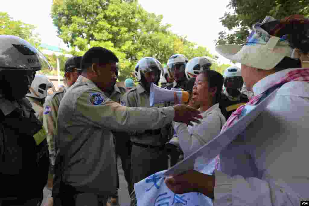 ក្រុមសន្តិសុខកំពុងទាញ និងអូសប្រជាពលរដ្ឋមានទំនាស់ដីធ្លីជាមួយក្រុមហ៊ុនចិន Union Development Group (UDG) ដែលតវ៉ាសុំអន្តរាគមន៍នៅមុខស្ថានទូតចិន ចេញពីស្ថានទូត នាថ្ងៃទី១៣ ខែសីហា ឆ្នាំ២០១៩។ (កាន់ វិច្ឆិកា/VOA)