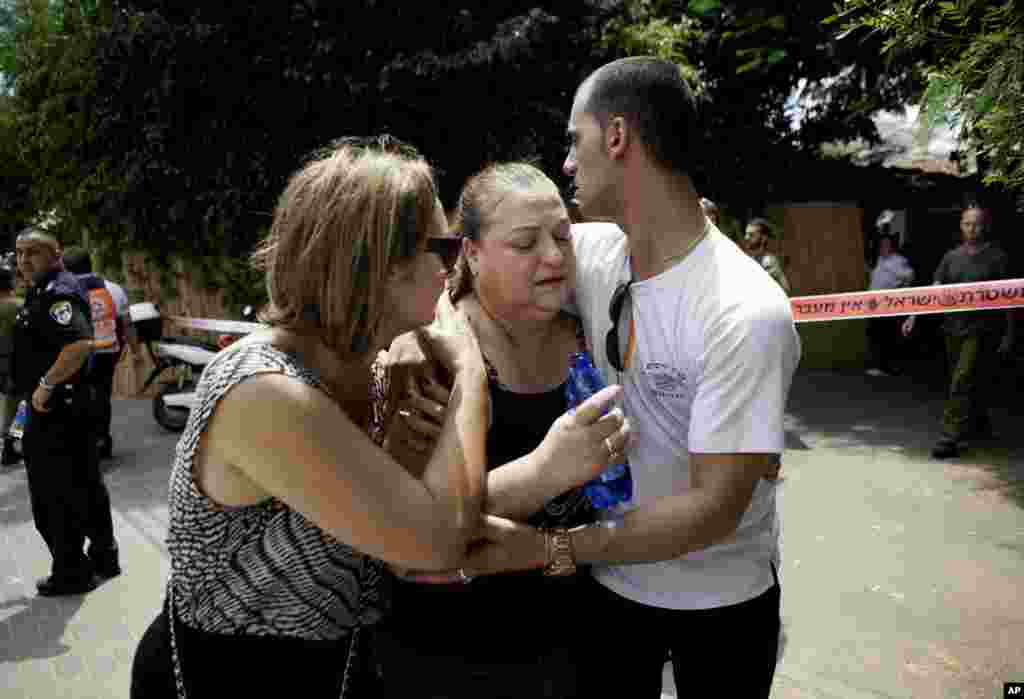 Israelis try to comfort a woman overcome by emotion after a rocket was fired by Palestinian militants from Gaza, into Yahud, central Israel, July 22, 2014.
