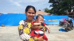 Ibu Mia (20) menggendong bayinya yang baru berusia tahun di Posko Pengungsian Buah Hati, Kelurahan Karema, Kota Mamuju, Sulawesi Barat. Selasa (26/1/2021). (Foto: VOA/Yoanes Litha)