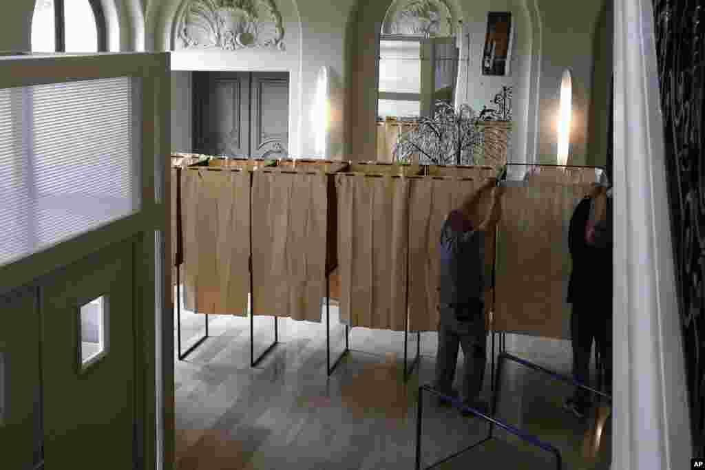 Workers prepare the voting booths at a polling station in Lambersart, northern France. The two-round presidential election will take place on April 23 and May 7.