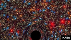 This computer-simulated image shows a supermassive black hole at the core of a galaxy. The black region in the center represents the black hole’s event horizon, where no light can escape the massive object’s gravitational grip. Light from background stars. Credits: ESA, and D. Coe, J. Anderson, and R. van der Marel (STScI)